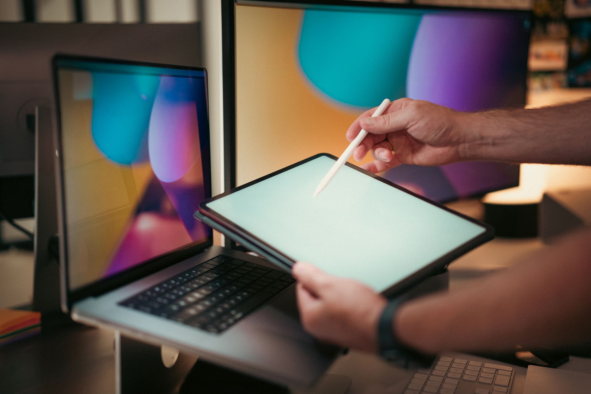Designer using a digital pen on a tablet with colorful screens in a modern home office setting. — A Complete Beginners Guide