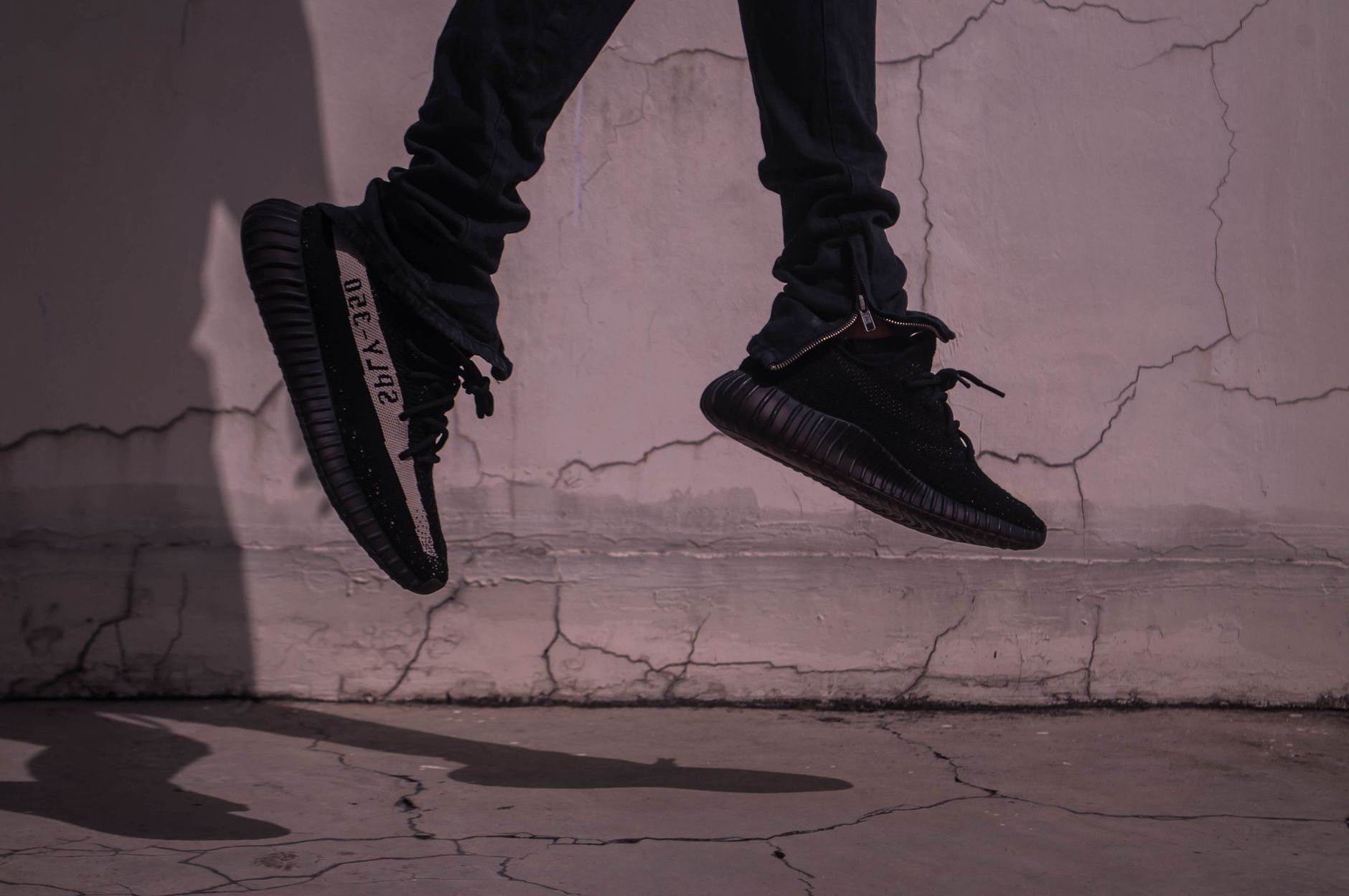 A stylish and dynamic urban photo capturing black sneakers in mid-jump against a cracked concrete wall. — Advantages of a Giv