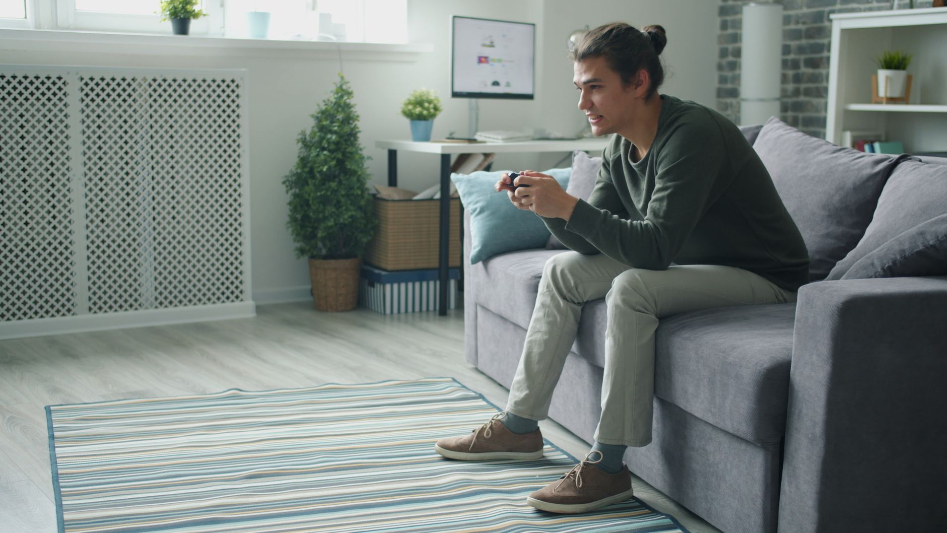 Smiling young man enjoying video games on a sofa at home. — Boost Your Athletics Gambling and begin Getting