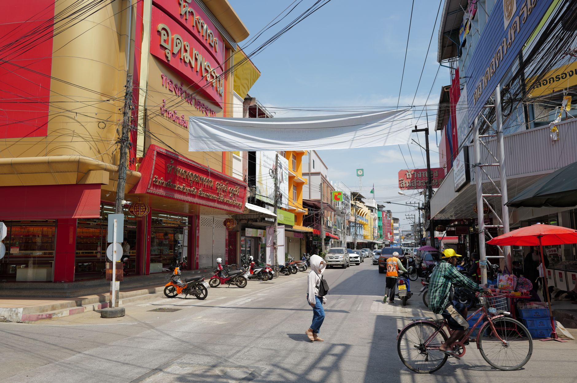 Lively urban street in Thailand with people, shops, and traffic under a sunny sky. — Collaborating for Better Outcomes: Dr Ia
