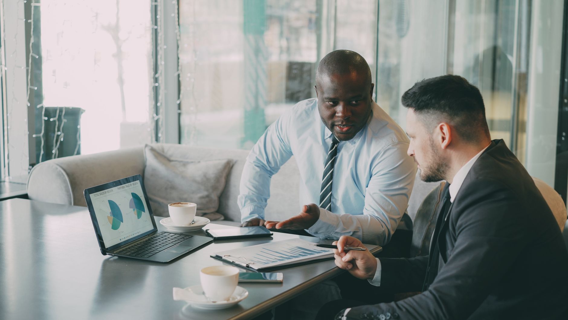 Two businessmen discussing data at a cafe while enjoying coffee. — Combi Style Vs. Apex Style: Which One Is Better For Garden