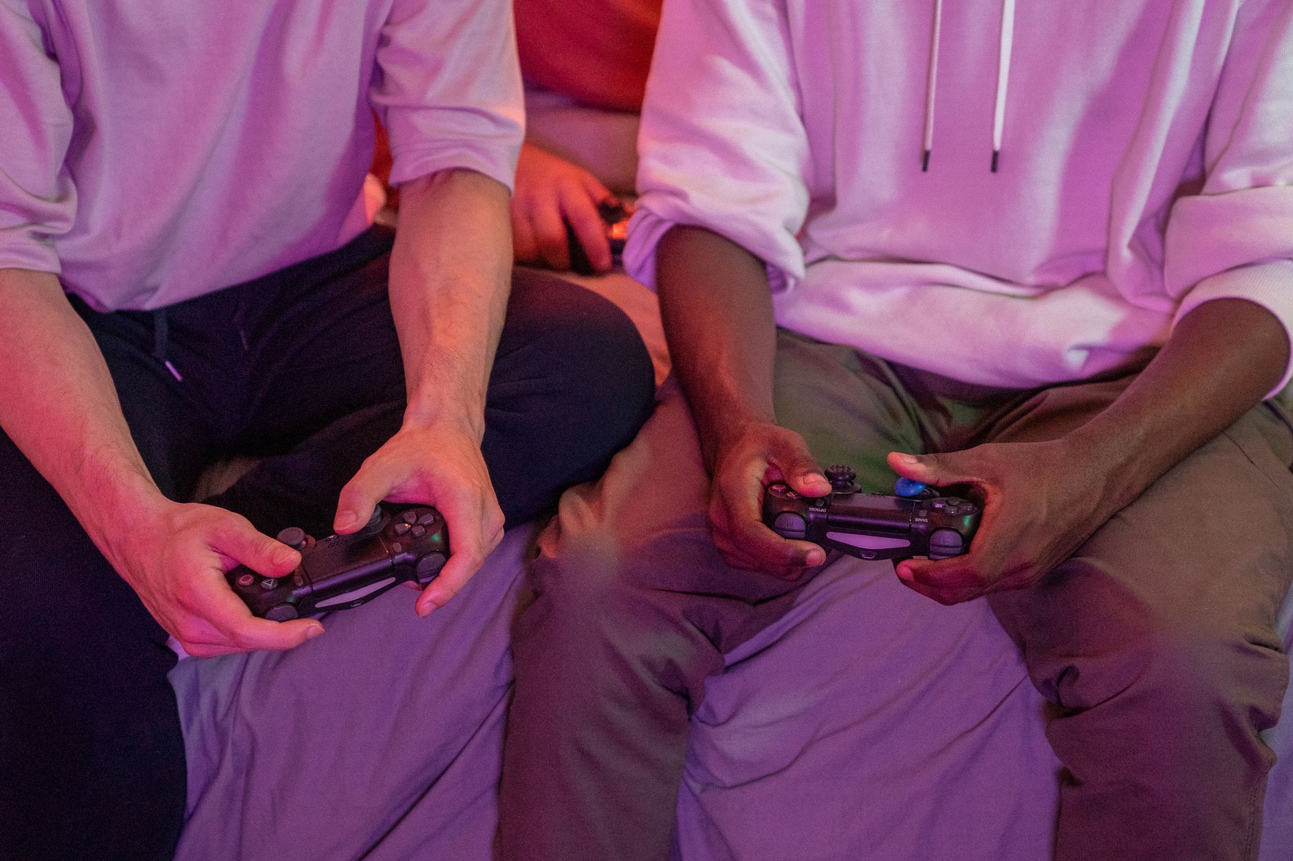 Two friends playing video games together at home, using controllers. — Crypto Gambling: A Brief Introduction To Bitcoin Roule