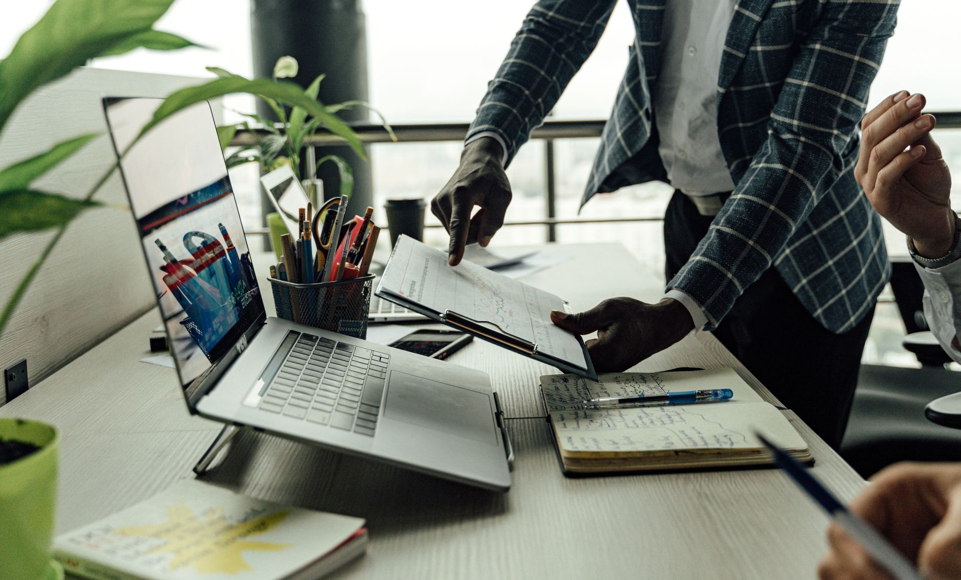 Colleagues collaborating on financial data analysis with a laptop in the office. — Demystifying Online Audio Mastering Progra