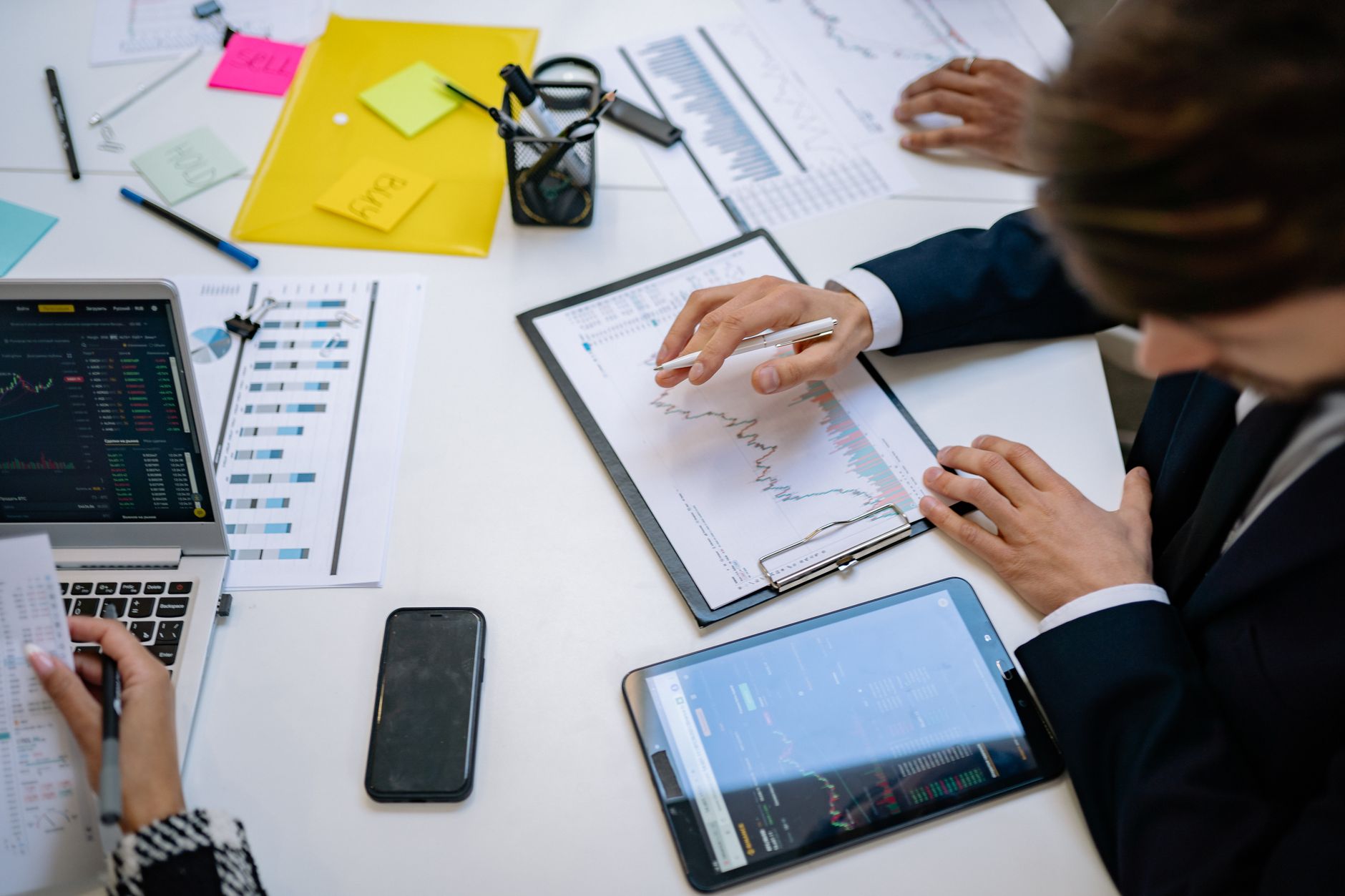 Team reviewing financial charts and digital data on tablets in an office setting. — Efficiency and Control: Must-Have Tools f