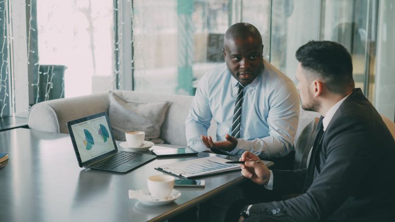 Two business professionals engaged in discussion over laptops and documents. — Elements Bar & Grill in Walsh Bay: The Perfect