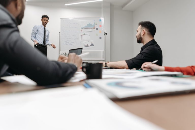 Corporate team during a presentation in an office setting, featuring discussions and planning. — Financial Empowerment in Com