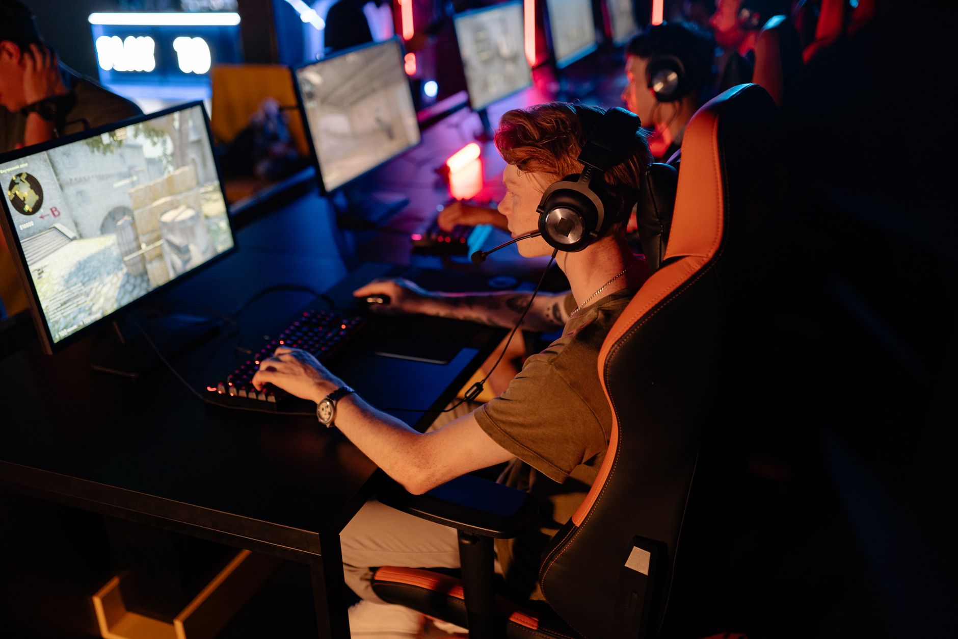 A group of gamers focused on a competitive match in a dimly lit esports arena. — Football Betting On A Money line Basis