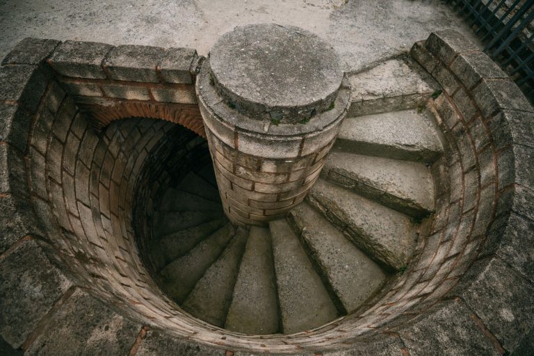 Top view of a spiraling stone staircase outdoors, showcasing architectural beauty. — HotLoot Casino: Ein Blick auf die Sicher