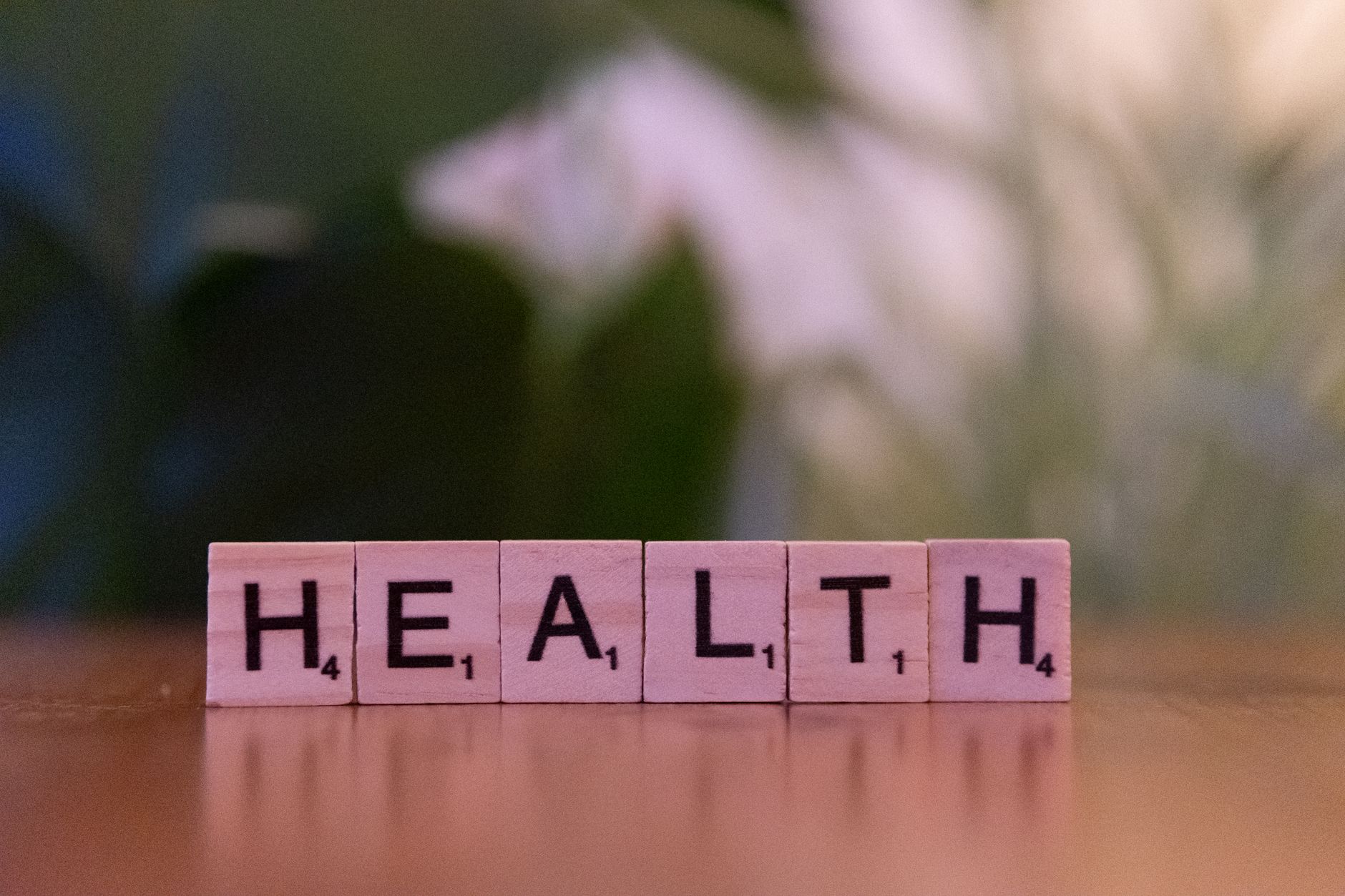 Close-up of Scrabble tiles spelling 'Health' on a wooden table with a blurred background. — How many cbd vape puffs should I