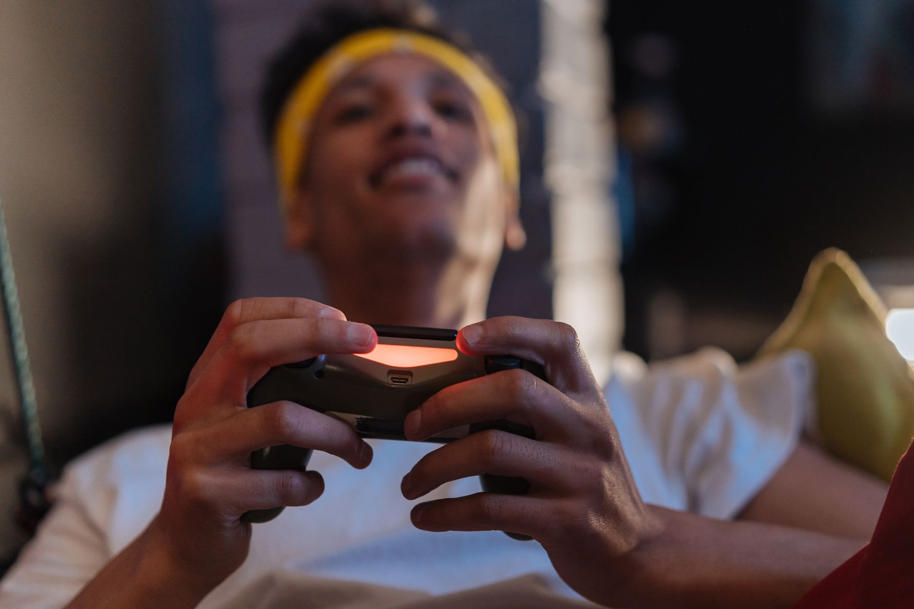 A relaxed gaming session with a close-up view of a man holding a game controller indoors. — How to Choose Which Games to Play