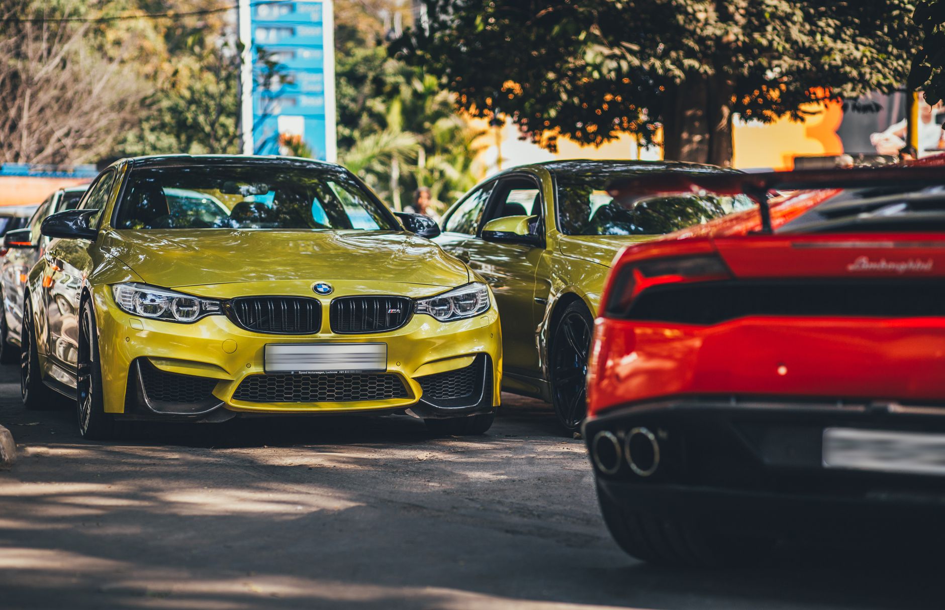 Vibrant BMW and supercar parked on sunny New Delhi road. — How to Take the Best Advantage of Automobile Shipping Quotes?