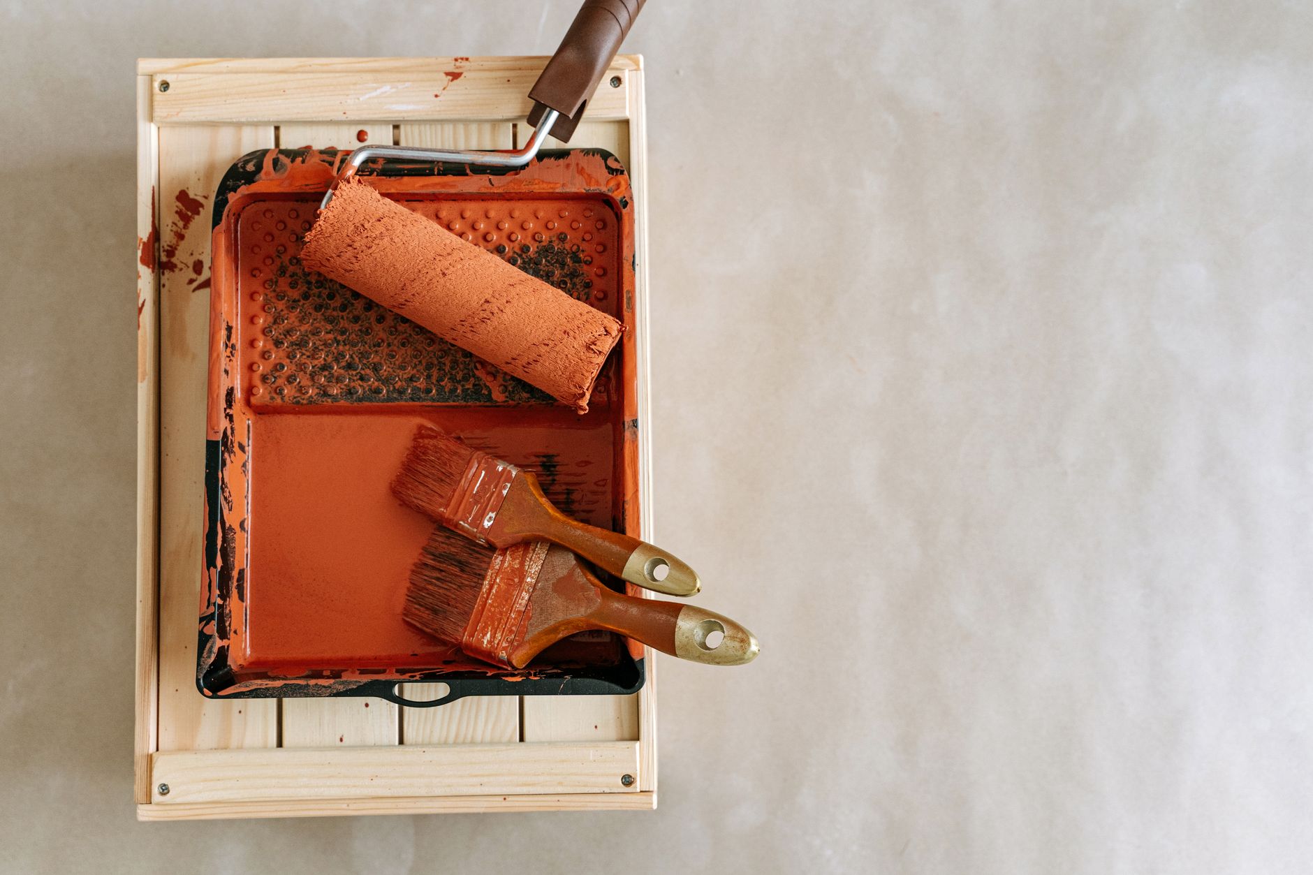 An overhead shot of paintbrushes and a roller in a tray, perfect for home renovation projects. — Instructions to Choose the R