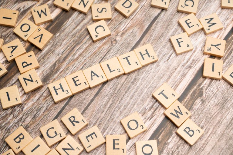 Scrabble tiles spelling 'HEALTH' on wooden surface, symbolizing wellness. — Key Features to Look for in Hospital Indemnity In