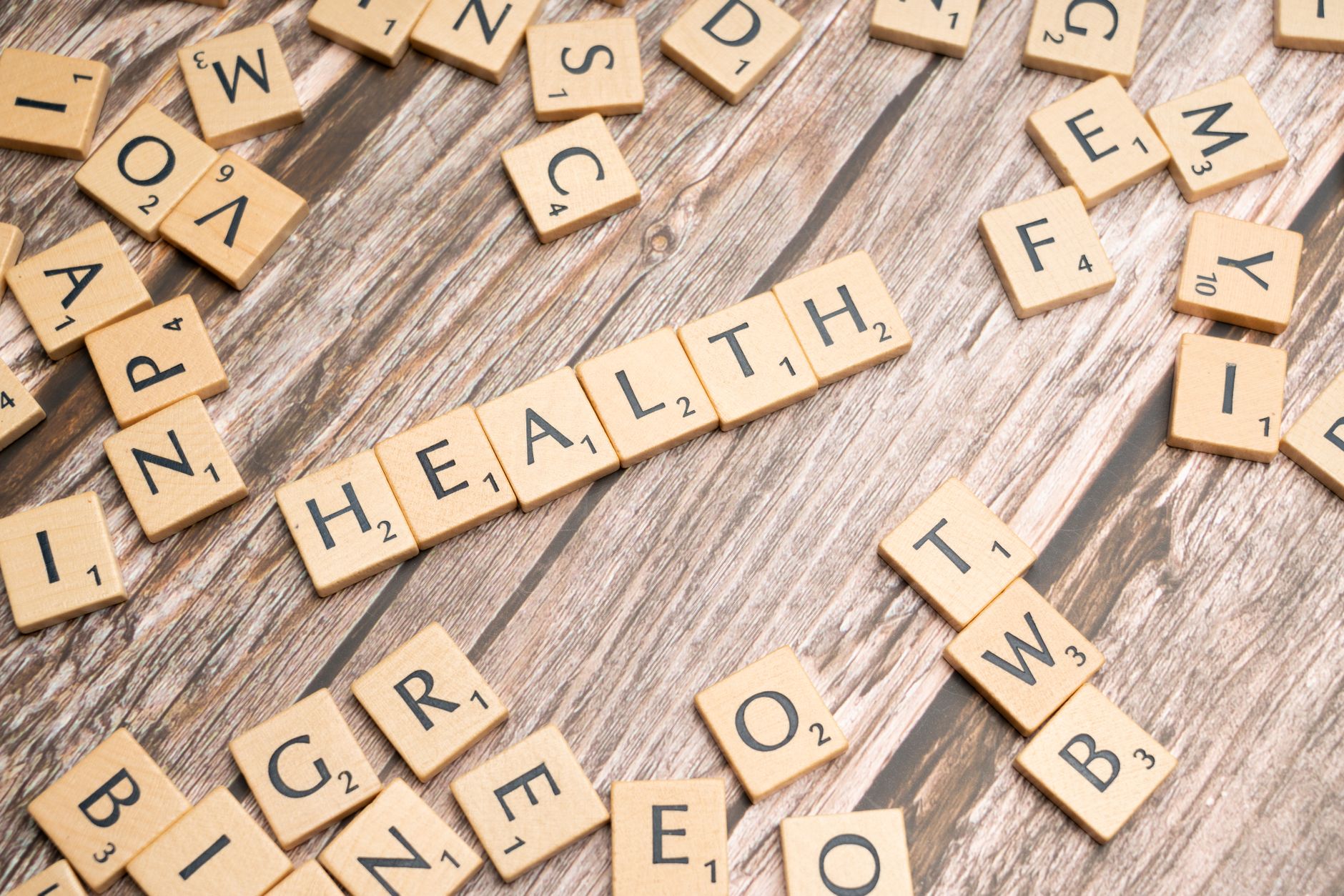 Scrabble tiles spelling 'HEALTH' on wooden surface, symbolizing wellness. — Key Features to Look for in Hospital Indemnity In
