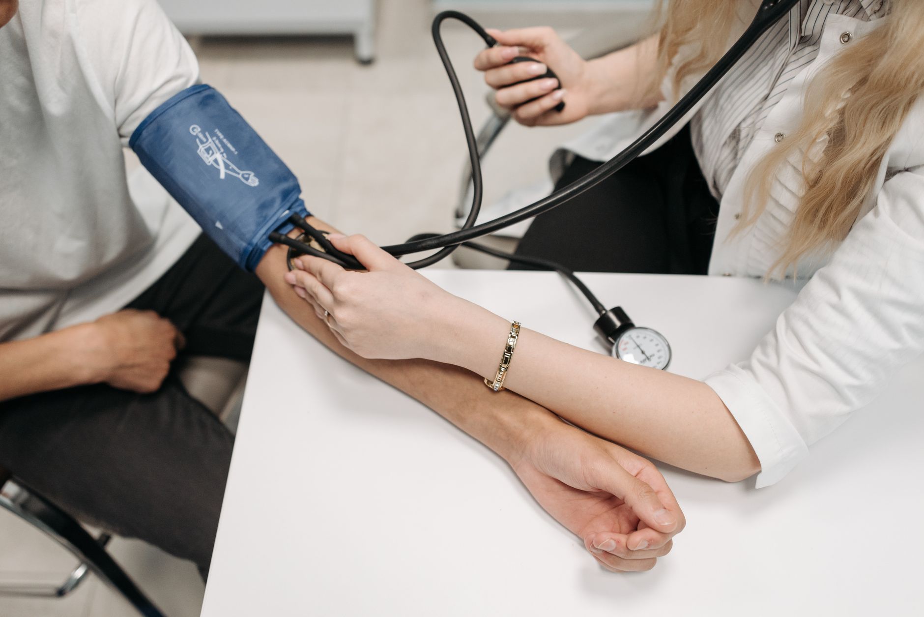 A doctor measures a patient's blood pressure with a sphygmomanometer during a consultation. — Medigap Plan N 2021 Costs