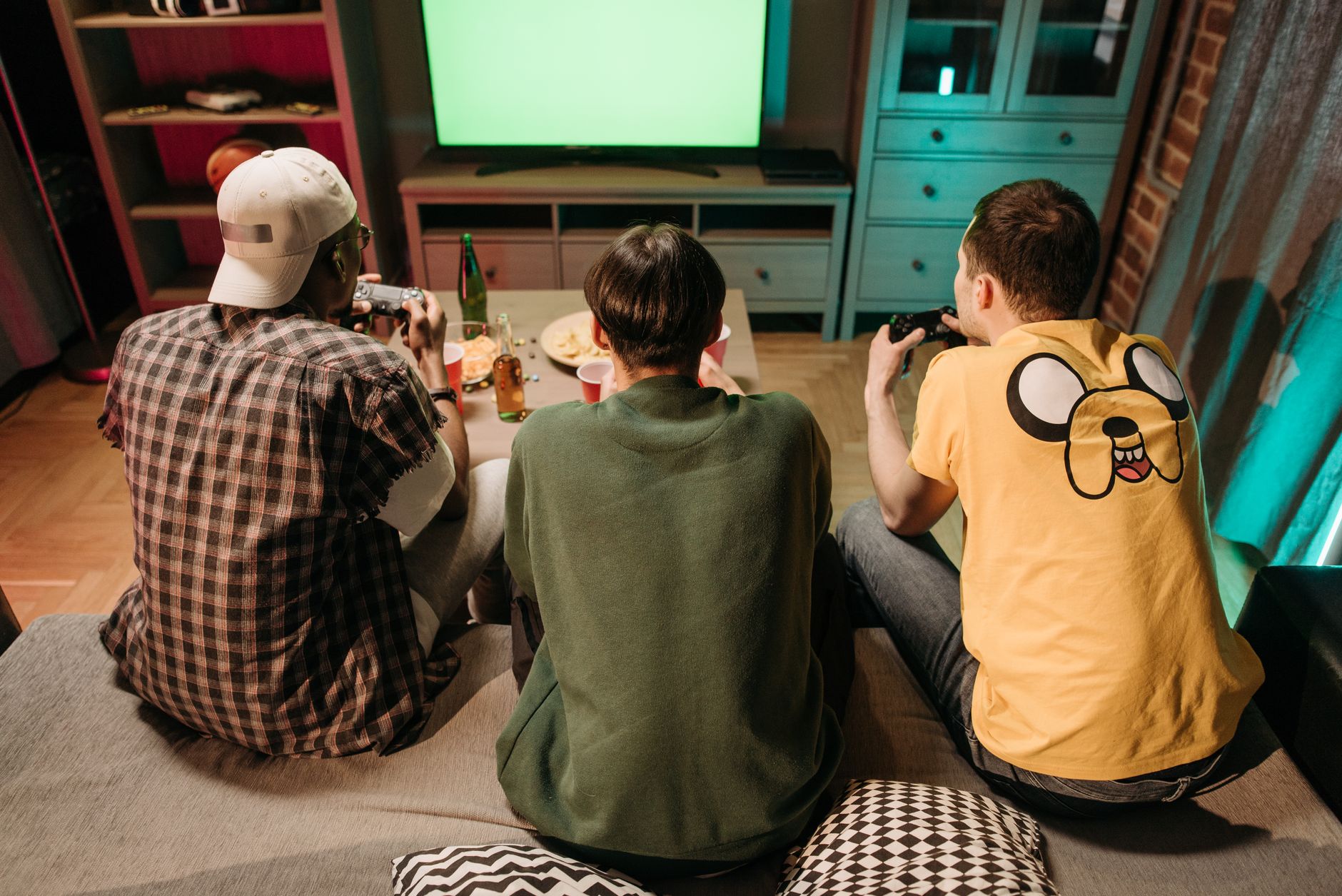 Three young men enjoying a home gaming session together, playing video games in a cozy indoors setting. — Navigating the Exci