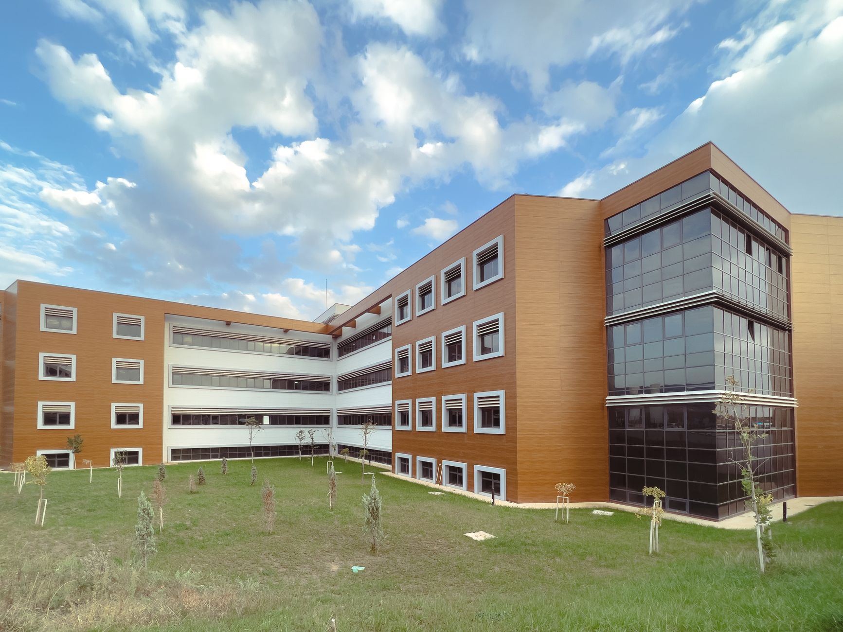A modern educational building with a grassy lawn and partly cloudy sky. — Pourquoi Lunubet Casino séduit-il autant les joueur