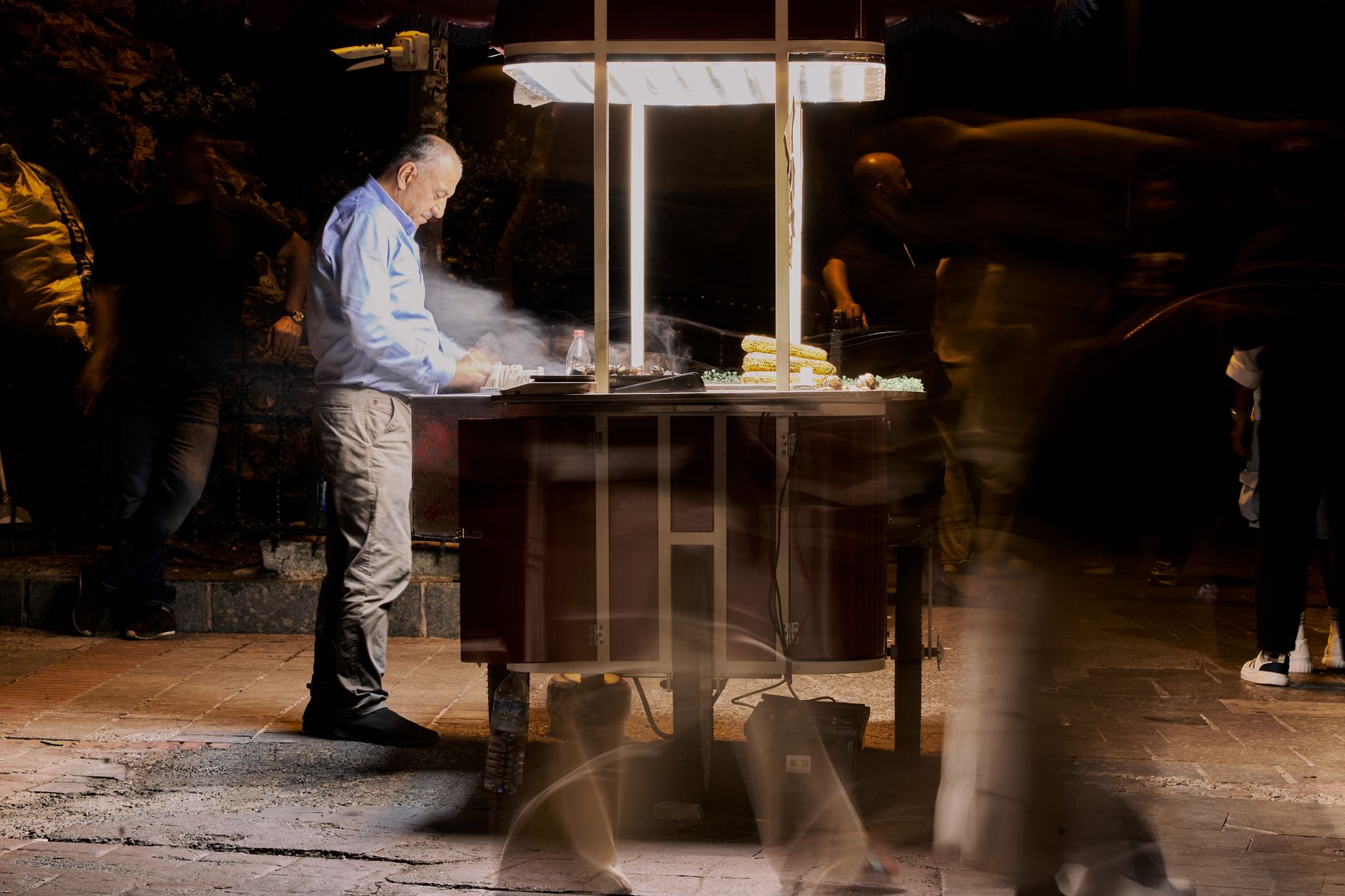 Street vendor cooking food at night with blurred people passing by. — Reach the Next Level with These Advanced Apex Hacks