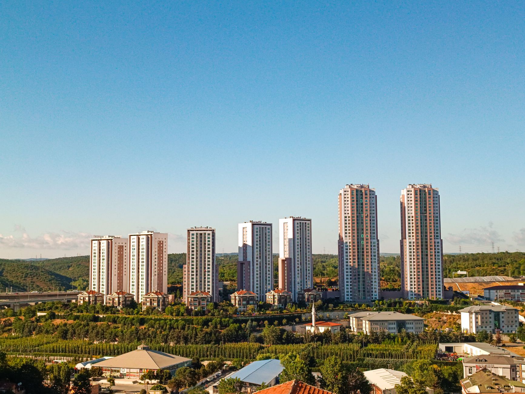 Aerial view of urban skyscrapers surrounded by greenery on a bright, clear day. — Reasons why the letter from Santa Claus mea