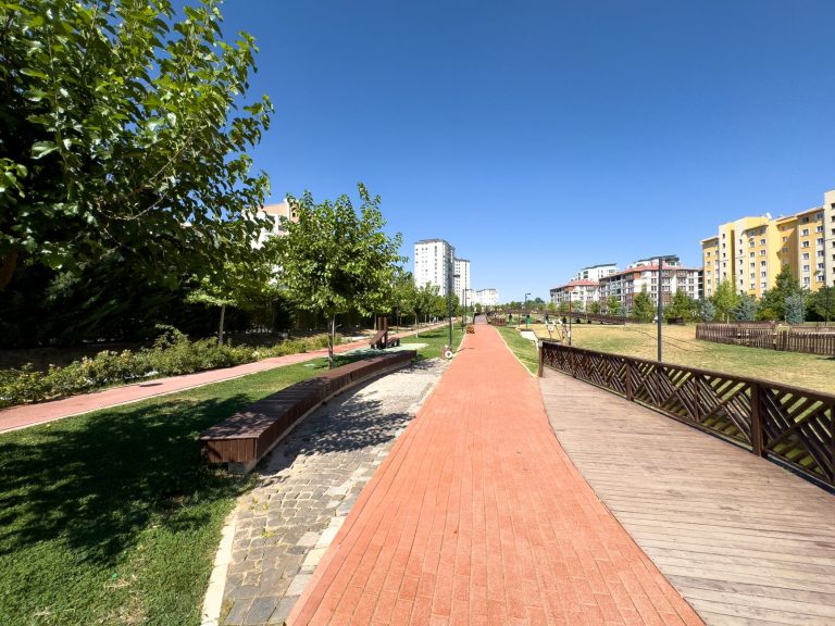 A vibrant, sunny park walkway with trees and buildings in Elâzığ, Türkiye. — Roulette blackjack et live dealer que choisir su