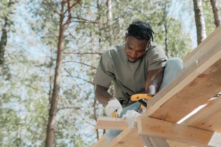 Skilled carpenter focused on building a wooden structure outdoors on a sunny day. — "Seamless Relocation: Moving Cleaning Sol