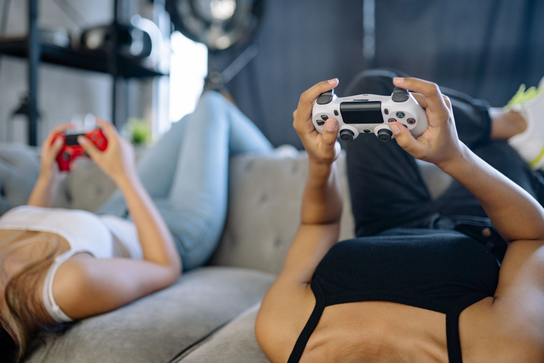 Two women relaxing and playing video games on a couch in a cozy living room. — Security and Safety in the Online Gambling Tot