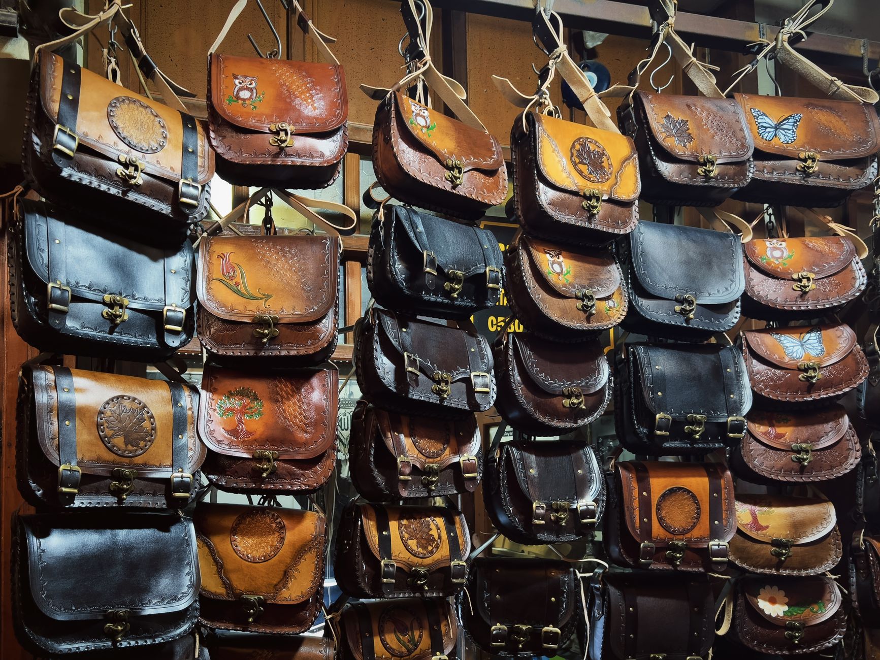 A collection of handcrafted leather bags with artistic designs on display at a shop. — Enjoy the Thrill of Winning at