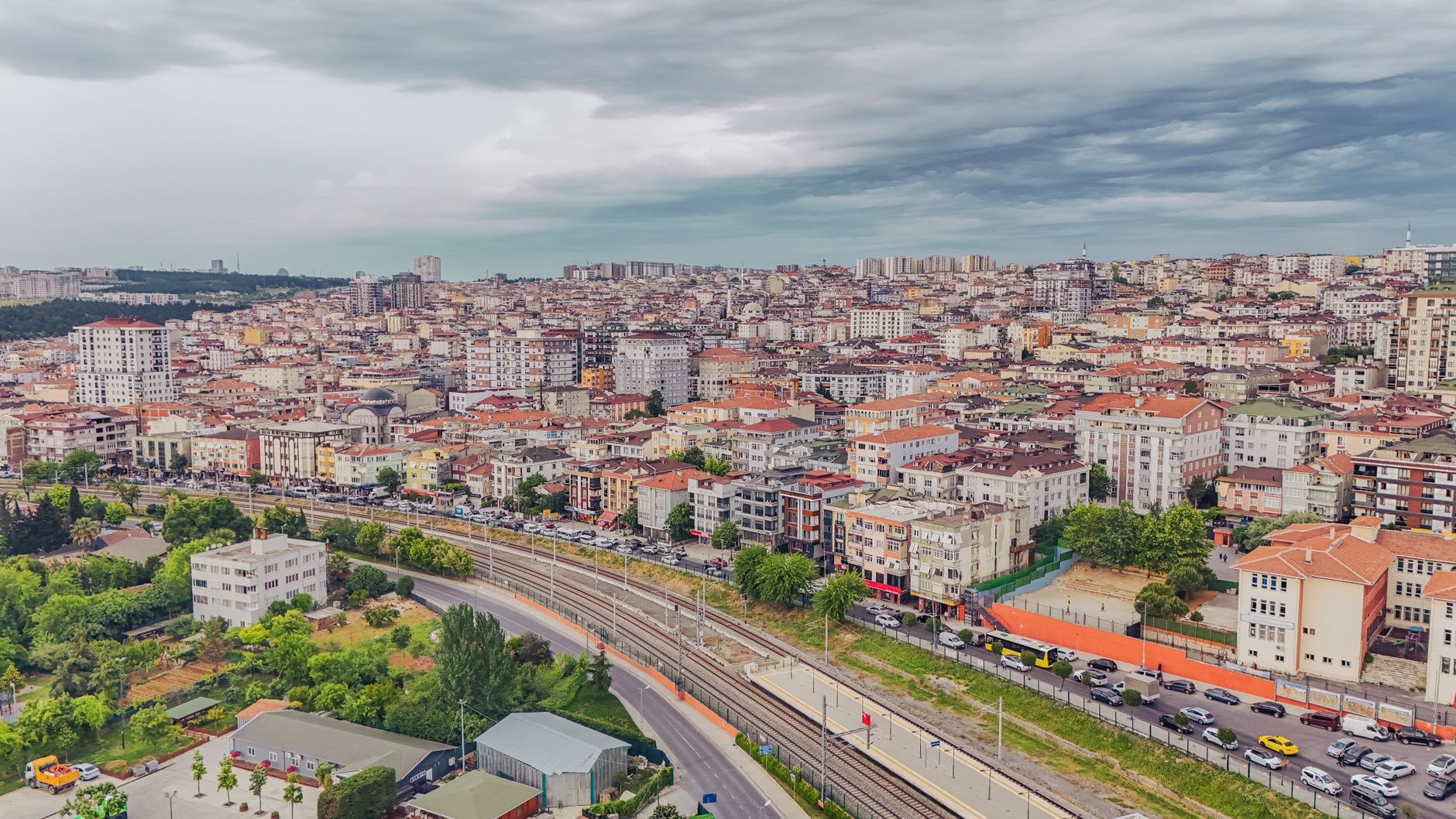 Aerial view of dense urban architecture with roads and greenery under cloudy skies. — Maximize the Visibility of Your