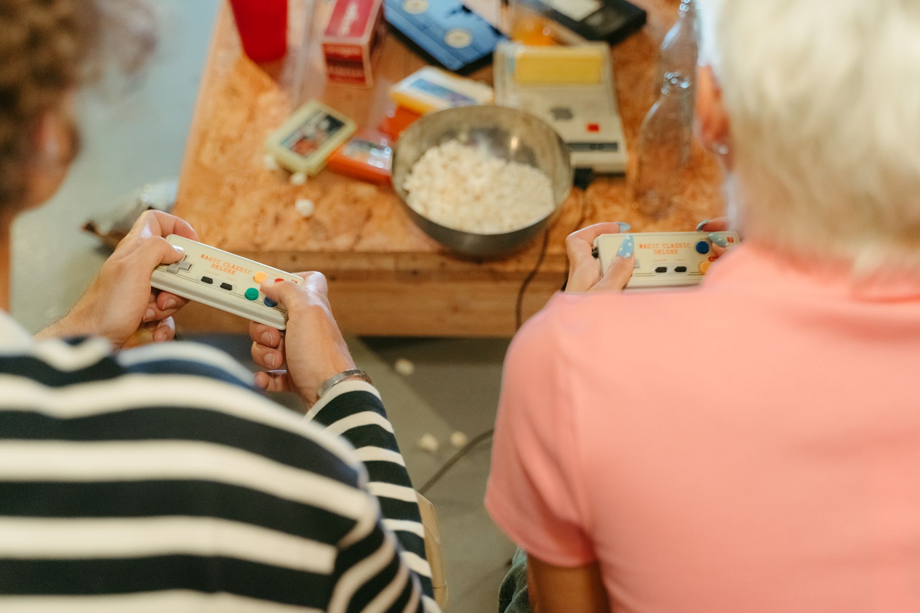 Two teenagers play video games together with snacks, creating a fun indoor atmosphere. — Play Your Favorite Games Any