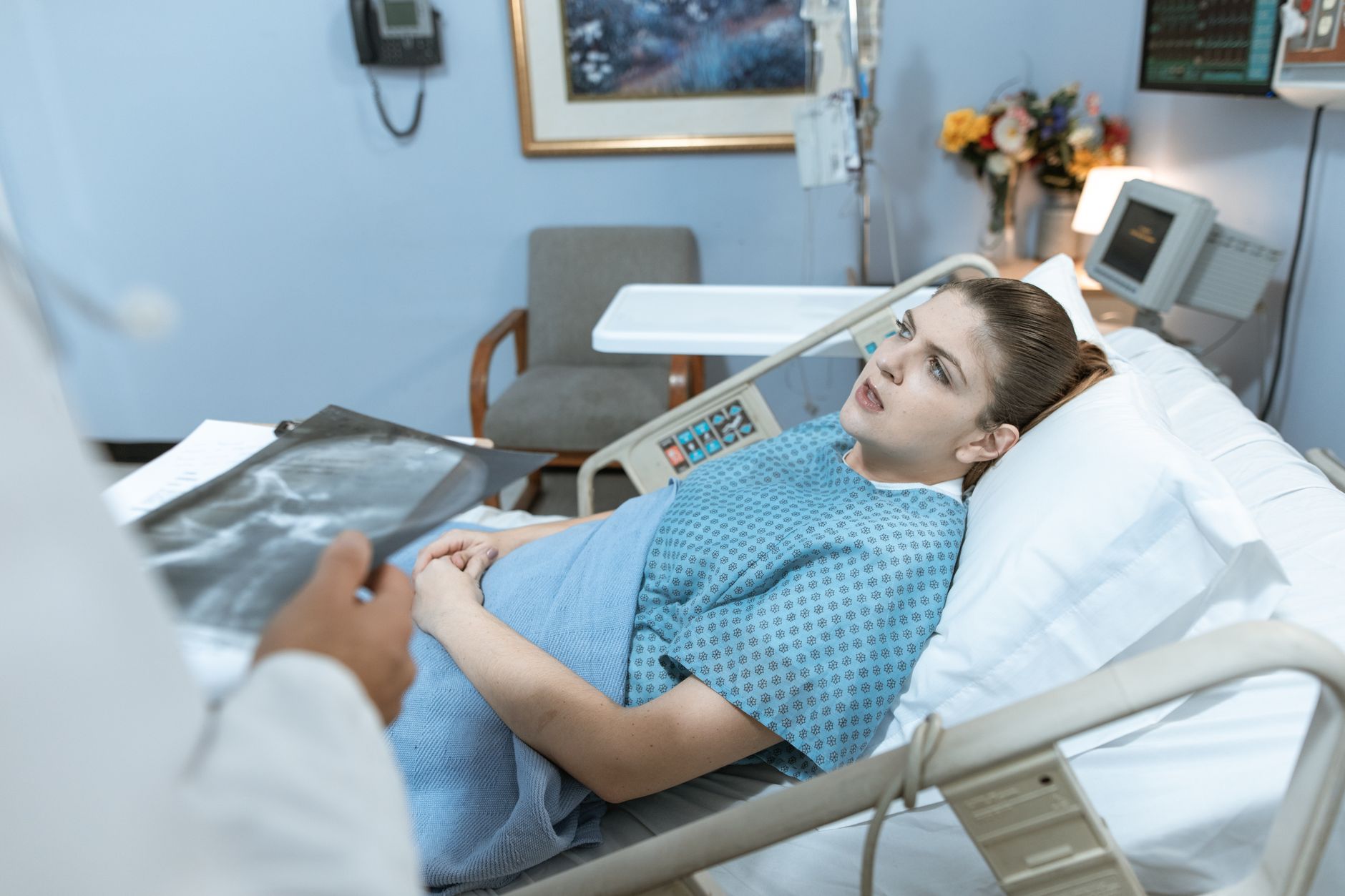 Caucasian woman in hospital bed receiving care from healthcare professional. — Study these tips for online athletics wagering