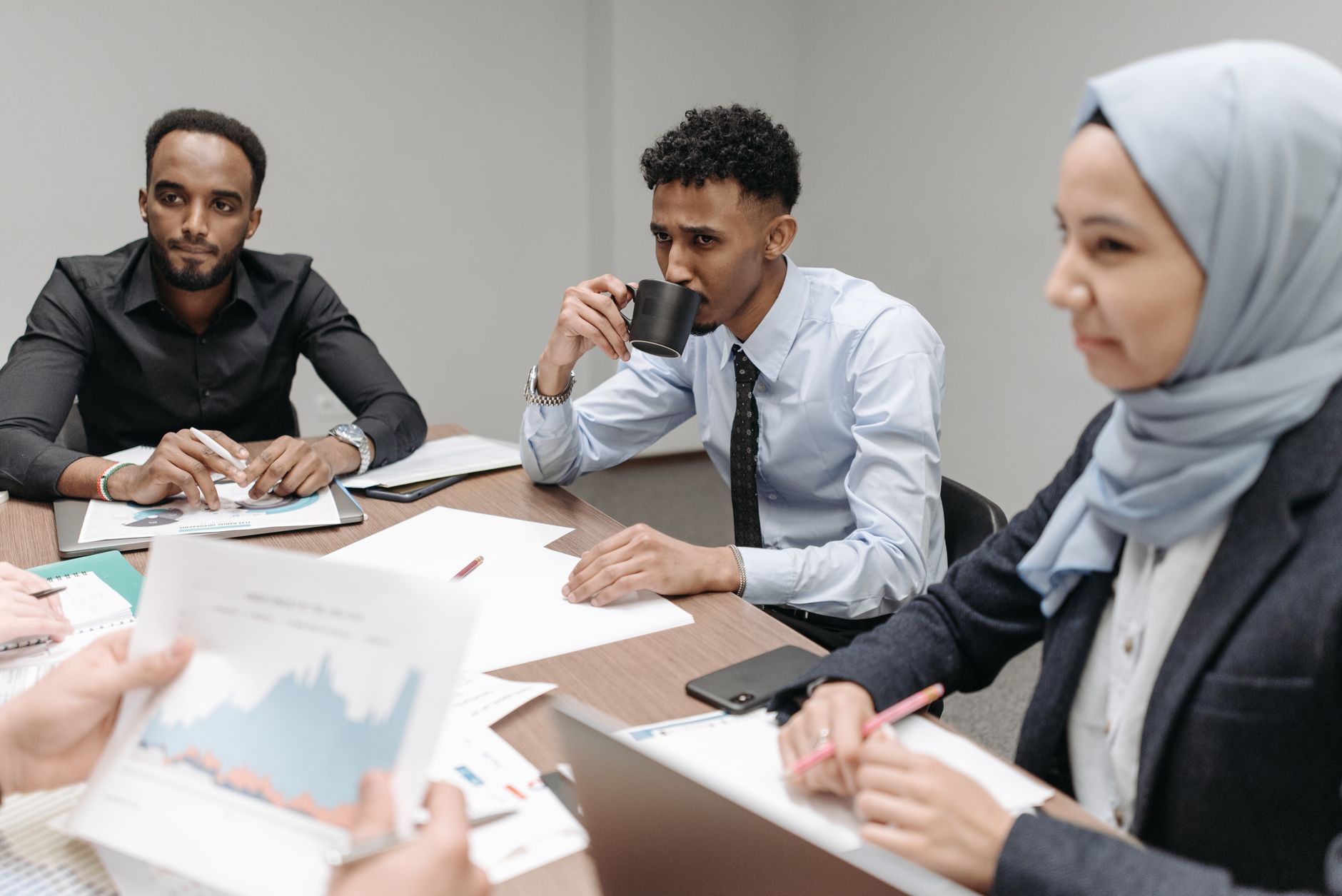 A multicultural team engaged in discussion during an office meeting, highlighting diversity and teamwork. — The Different Kin