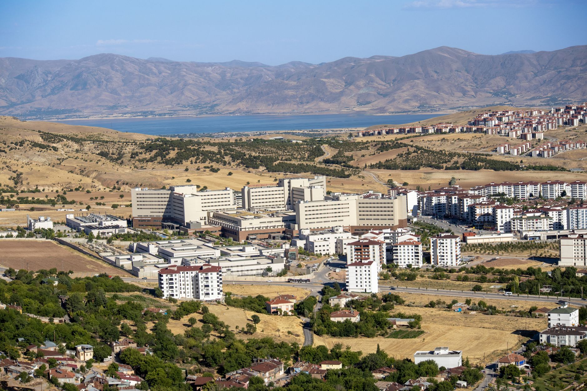 Stunning aerial photograph capturing the expansive cityscape of Elâzığ, Türkiye, with distant mountains. — The Impact of the