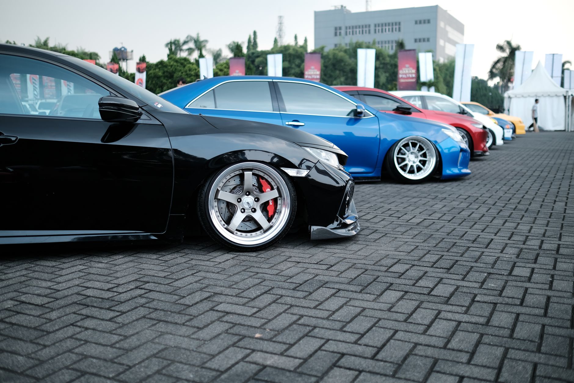 Showcase of sleek customized sports cars parked in an outdoor exhibition. — Top Four Tips on How to Get Your Dream Luxury Car