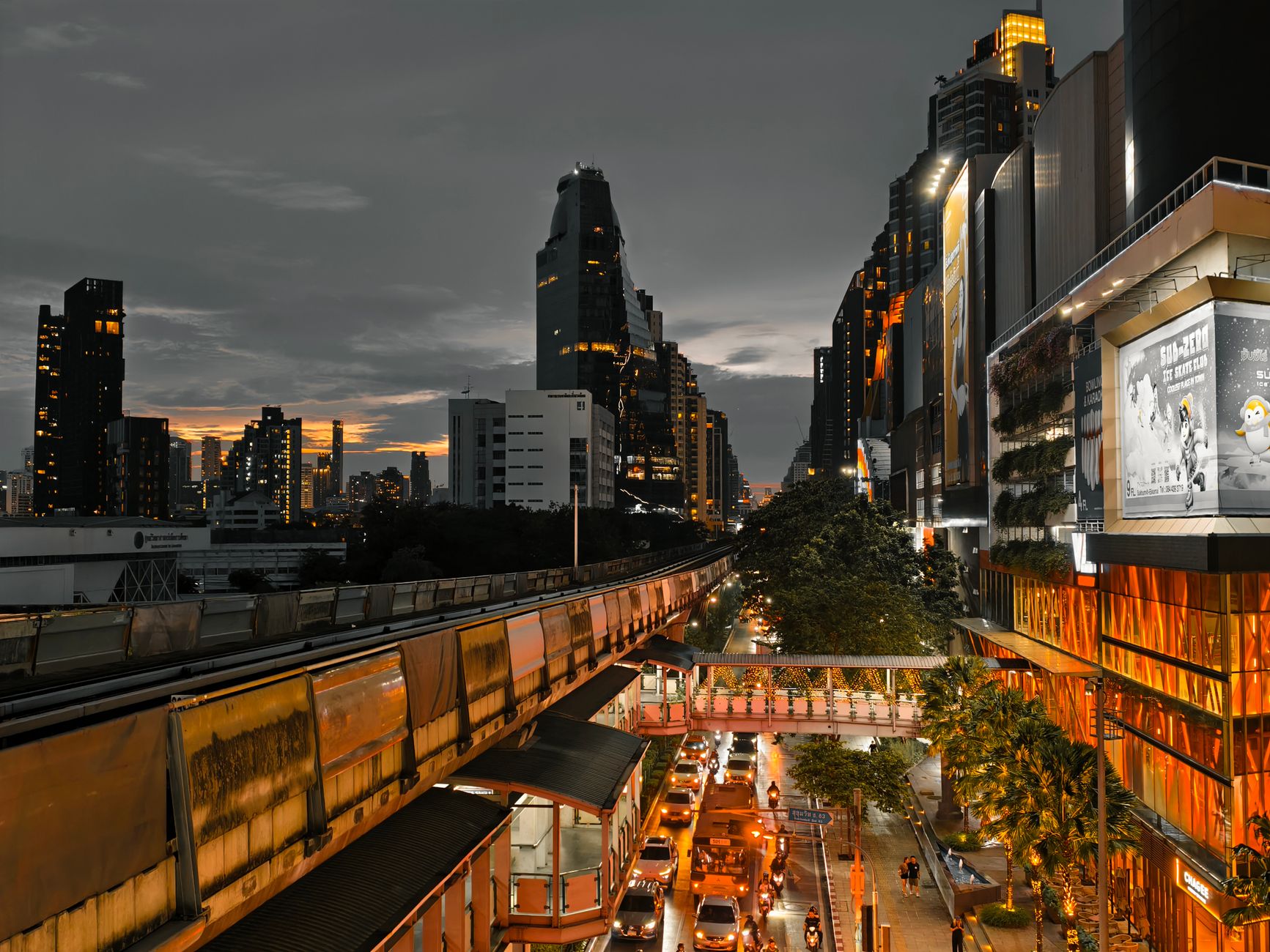 Cityscape at twilight showing busy traffic, skyscrapers, and an elevated train line in an urban setting. — Unwind in Style: G