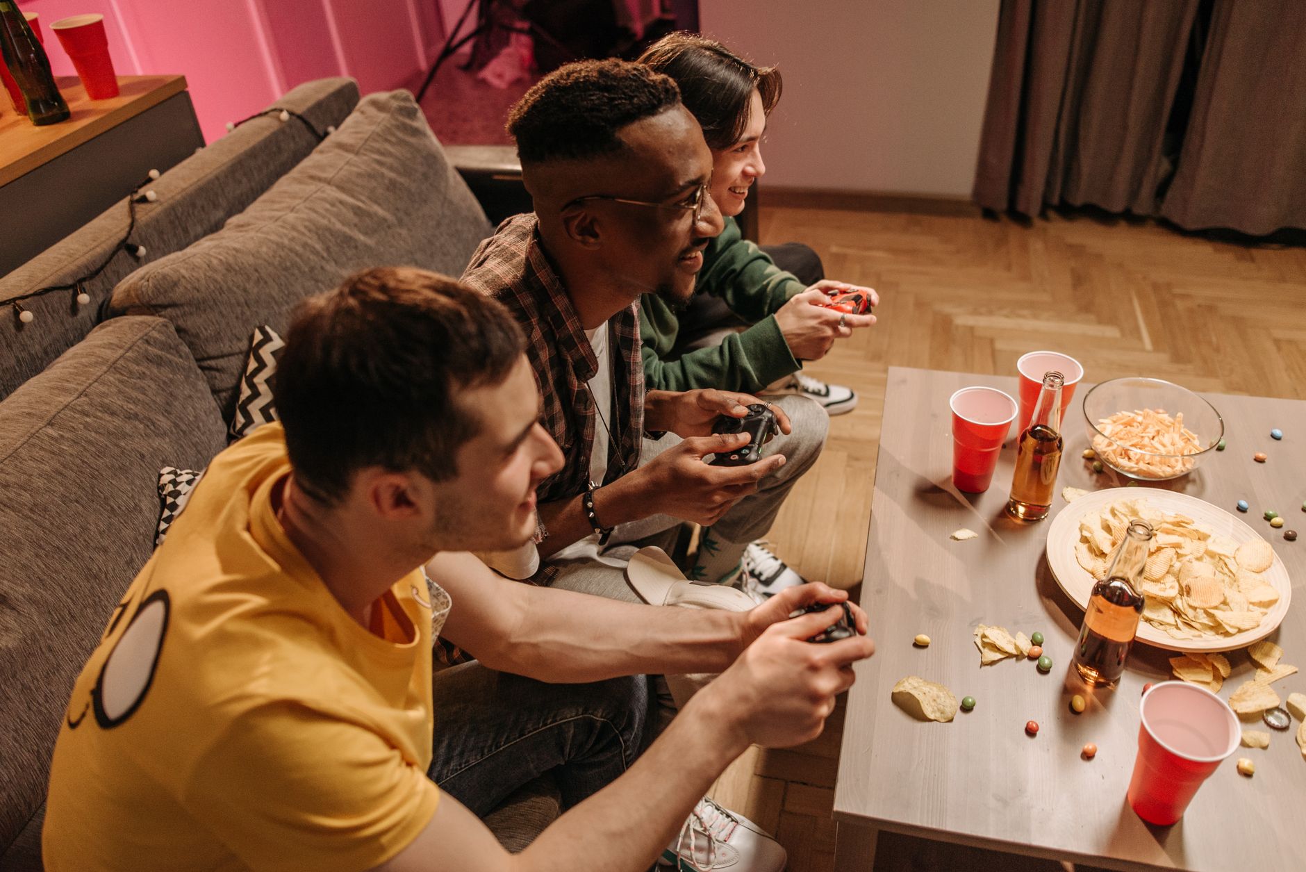 Group of friends playing video games and enjoying snacks indoors. — Want To Win in Football Betting? Play Here At w888!