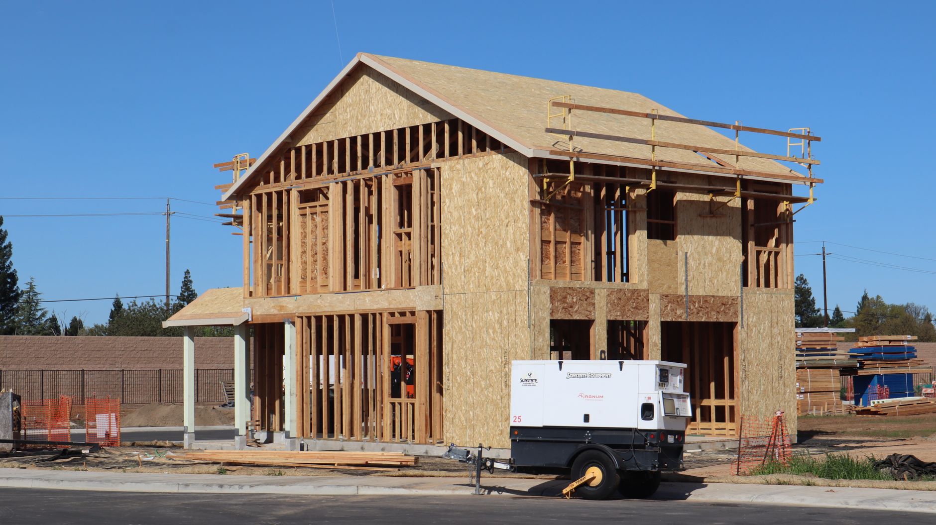 A new house under construction in Elk Grove, showing wooden framing and building materials. — What dumpster size should you r
