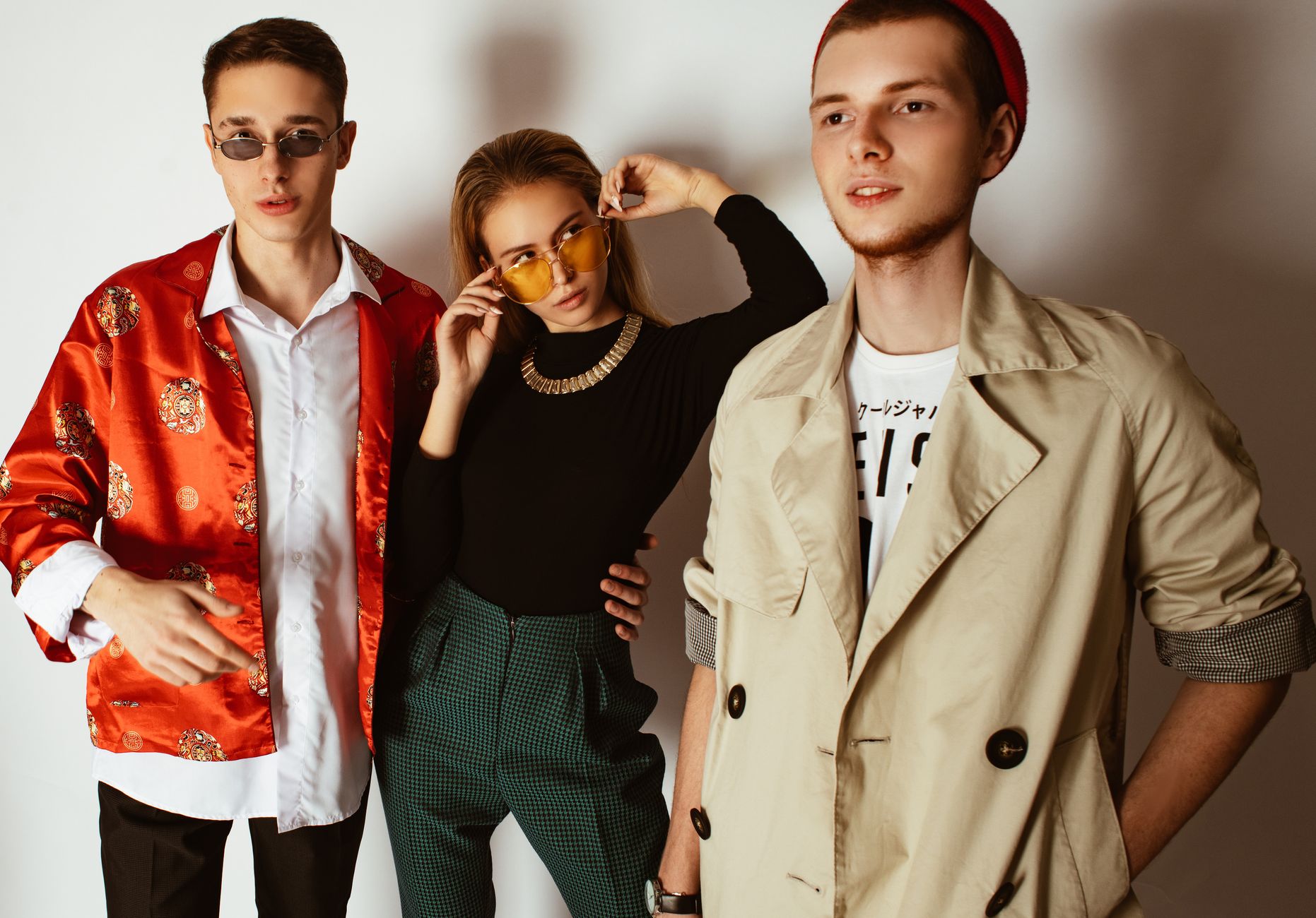 Fashionable portrait of three adults showcasing trendy outfits and accessories indoors. — What to wear hiking?