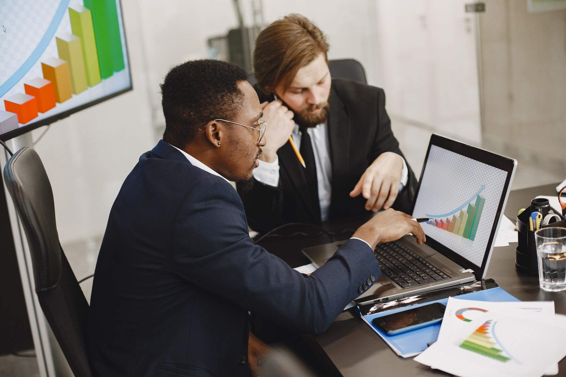 Two business professionals working on growth charts using laptop in an office setting. — Why Beet Puffs Are The Best Snack Fo
