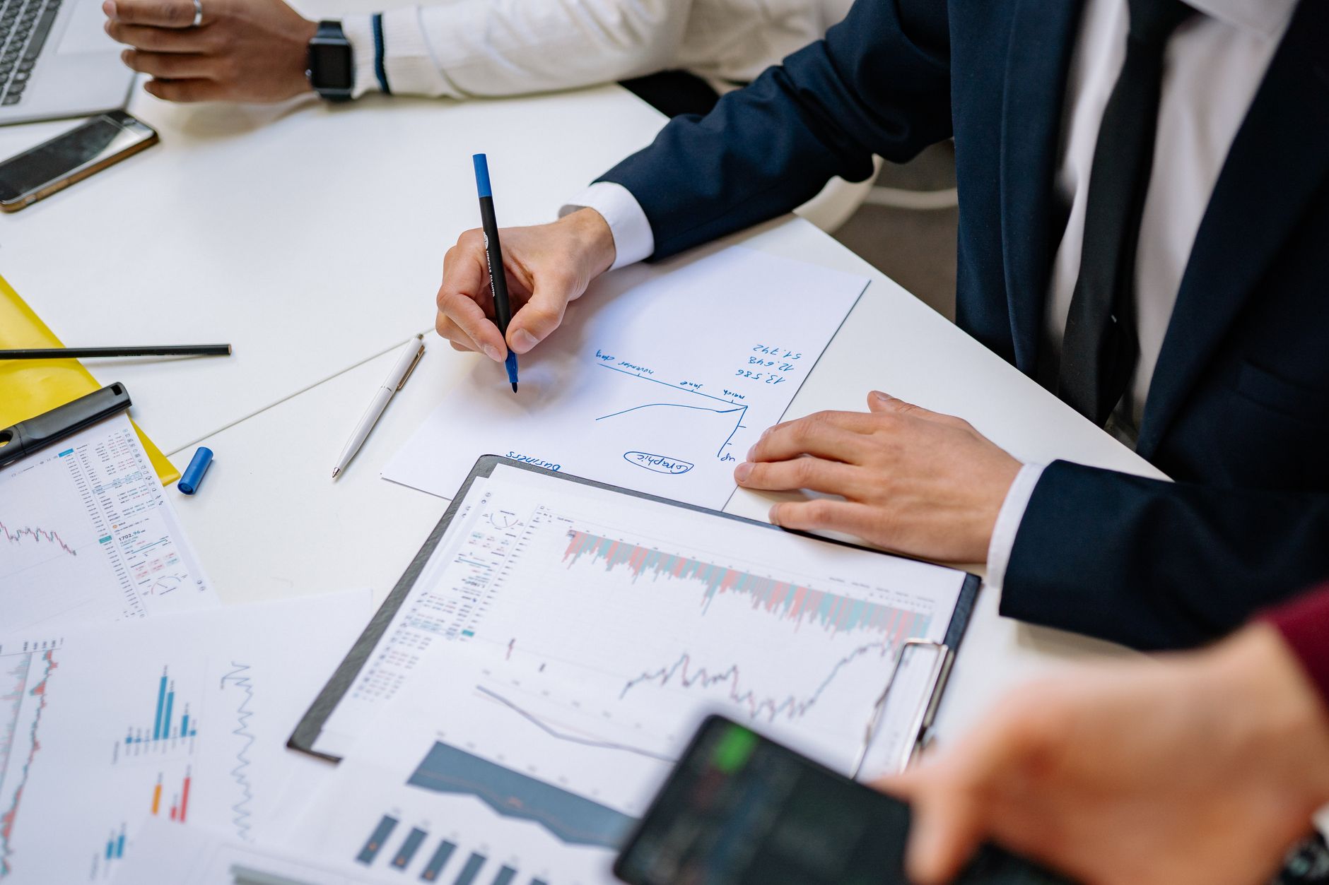 Professionals analyzing financial charts in a corporate setting. — Why opt for MacBook? Things to know about MacBook repair s