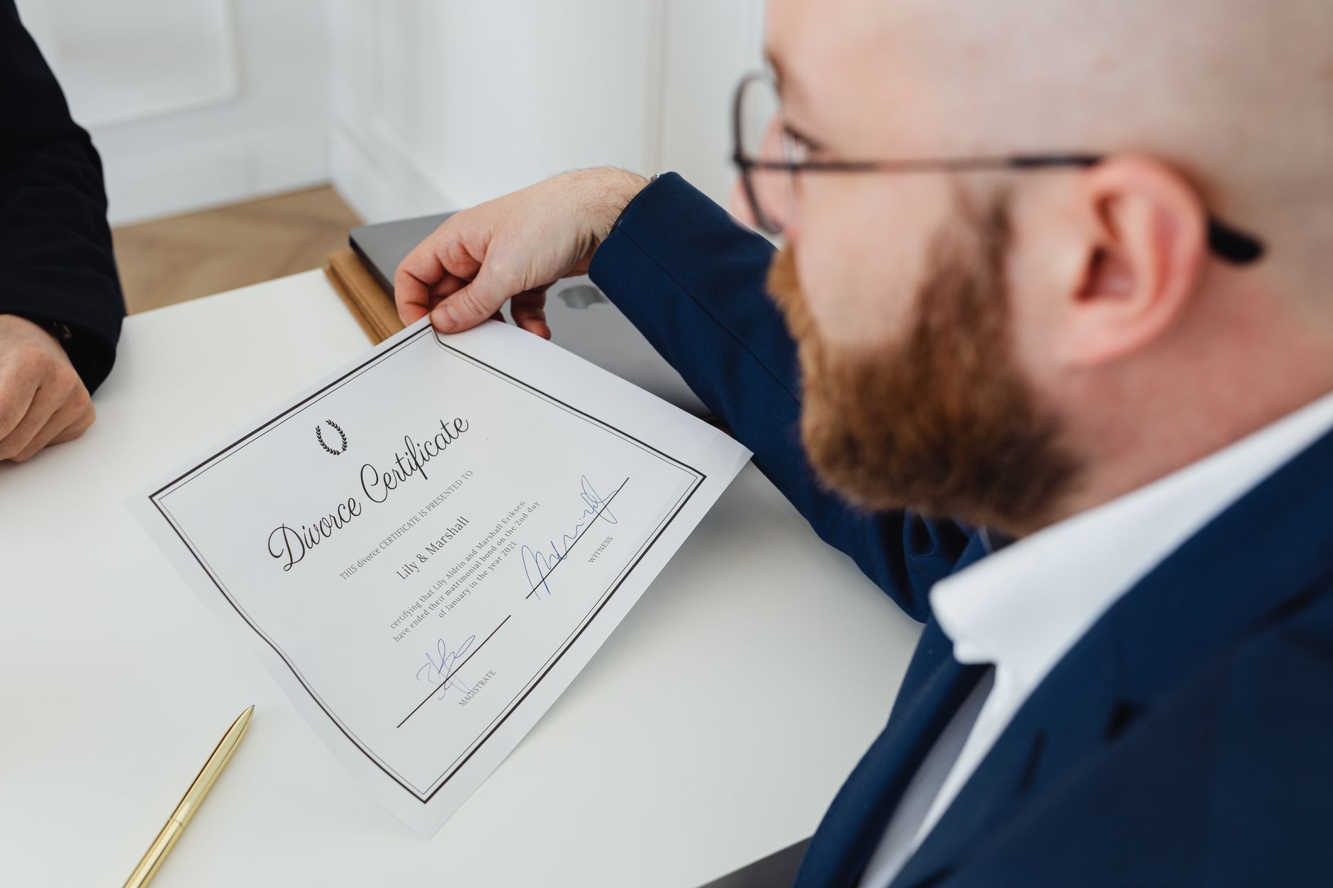 A man holding a divorce certificate in a formal office environment. — Work with an Experienced Lawyer If Your Guardian Disabi